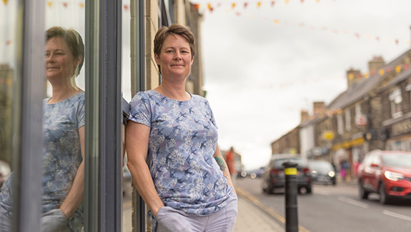 woman-leaning-against-store-window-my-trauma-&-difficult-start-Gill-Castle-Dansac-living-with-an-ostomy-article-image